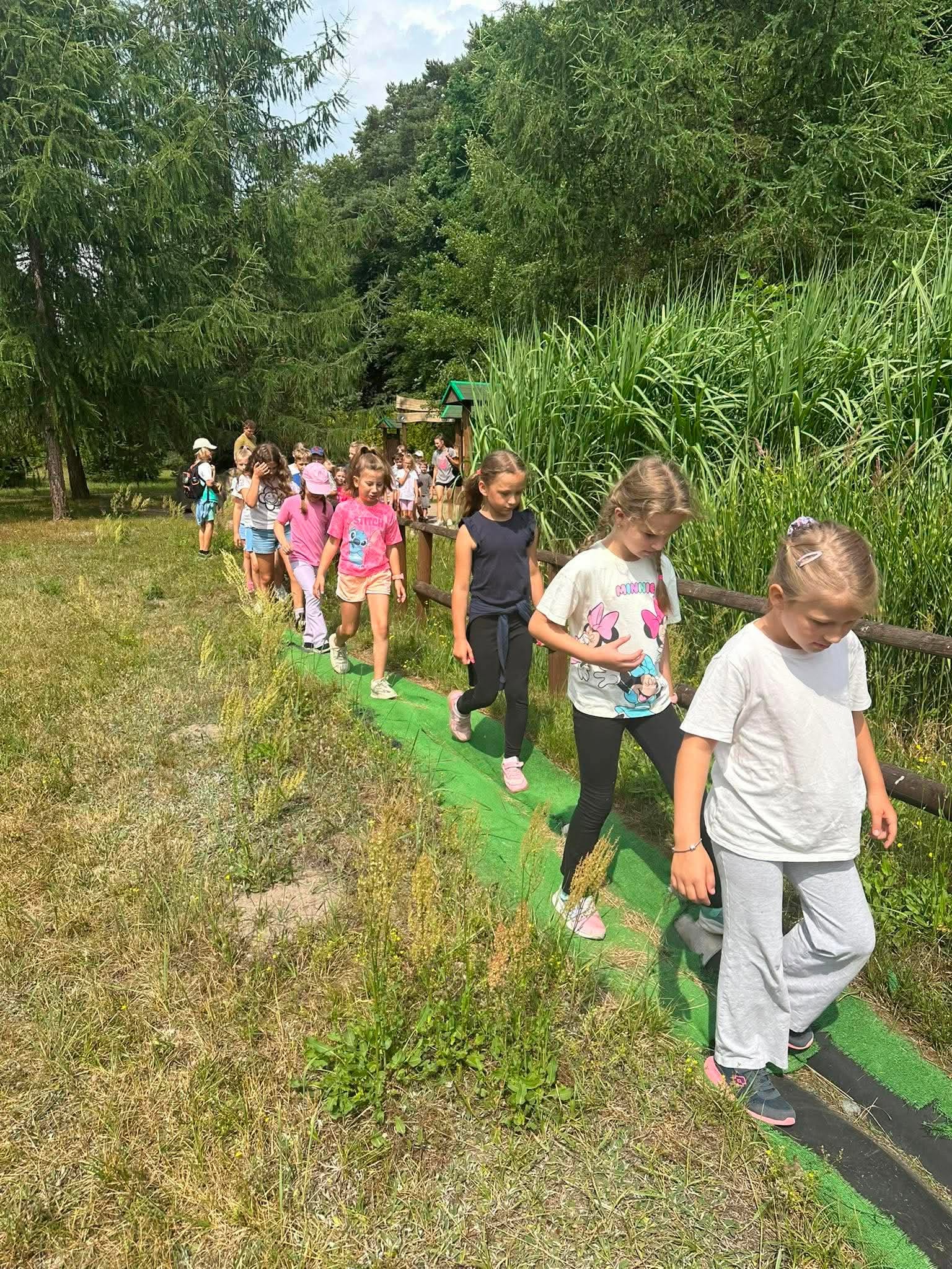 dzieci chodzą po sztucznym bagnie