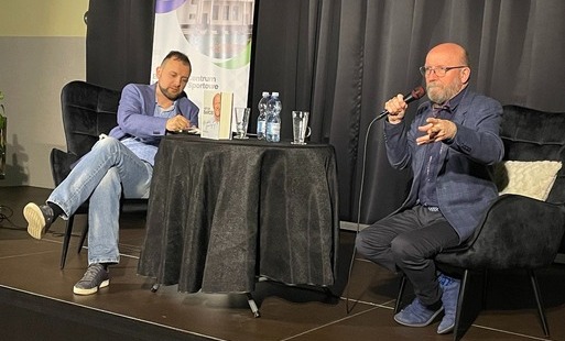 dwie osoby siedzące na scenie